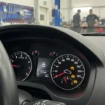Lumina de avertizare Check Engine aprinsă pe bordul unei mașini moderne, indicând posibile probleme ale motorului sau sistemelor electronice.